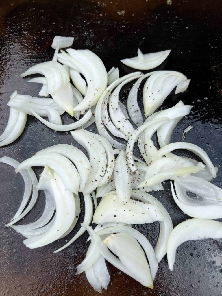 Raw onions on a Blackstone. 