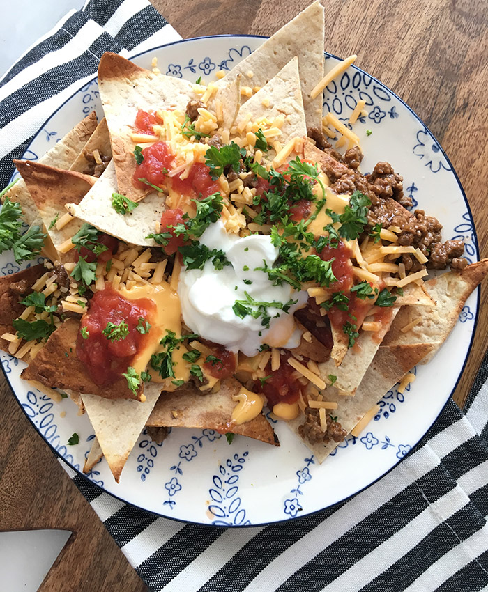 Nachos made on a Blackstone Griddle topped with ground beef, cheese, and sour cream. 