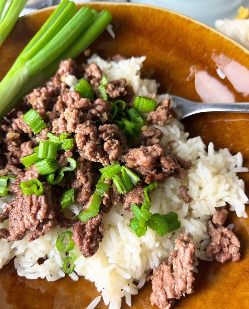 Beef Bulgogi topped with scallions and served with rice. 