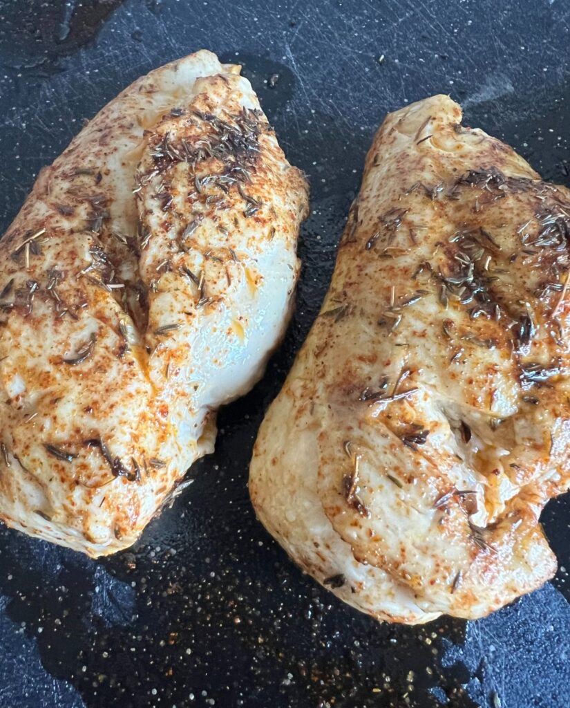 Fully cooked seasoned chicken breasts that were made on a Blackstone griddle. 