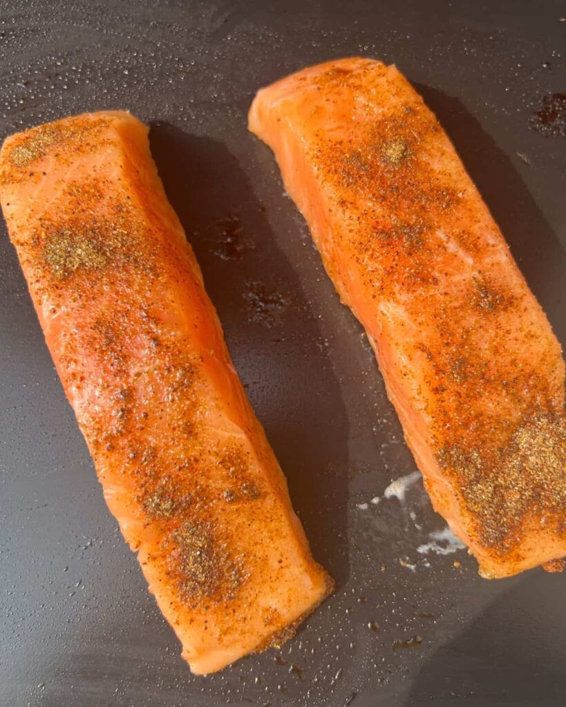 Salmon cooking on an outdoor griddle. 