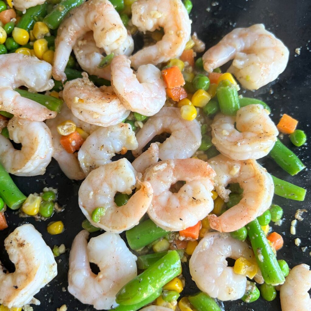 Shrimp and vegetables cooking on a plate. 