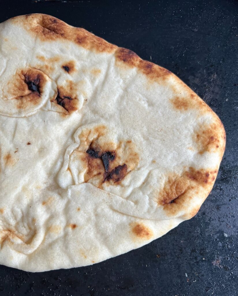 Cooked flat bread on a heated griddle. 
