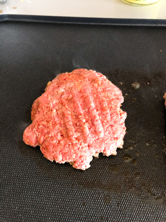 Smashed Burger Patty cooking on a Blackstone. 